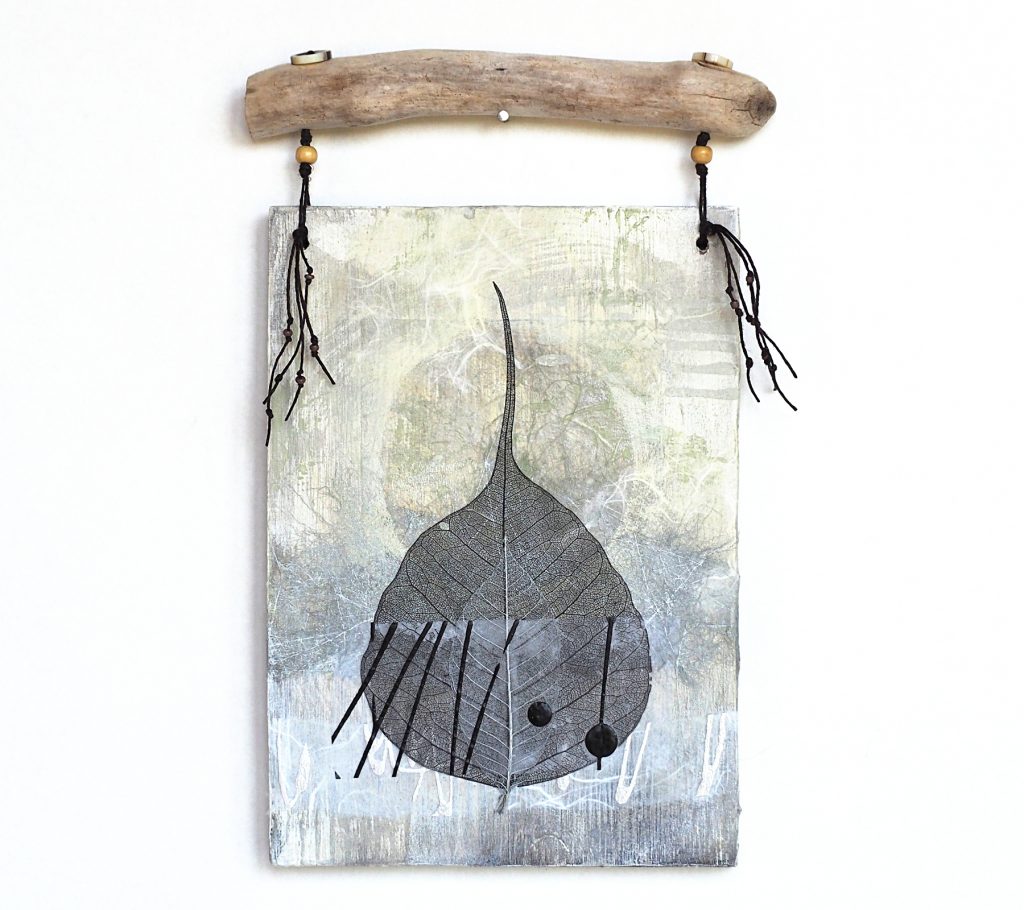 Mixed media wall hanging with leaf.